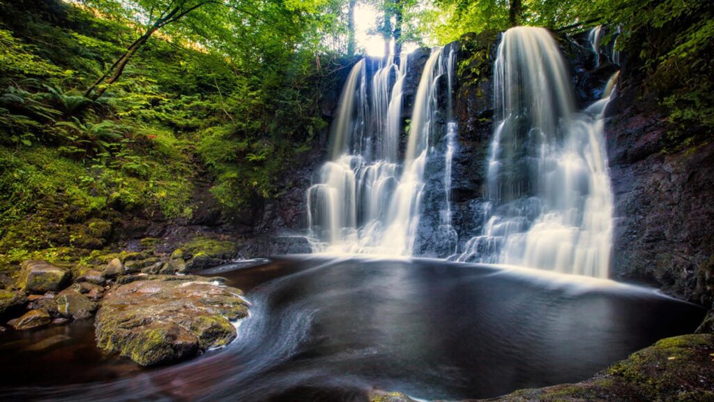 water cascading into a dark pool in County Antrim, Ireland